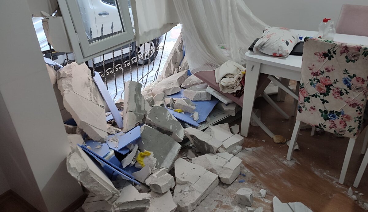 Kazada dairenin duvarının bir kısmı yıkıldı. Demir parmaklık ve pencerelerde de kaza nedeniyle hasar meydana geldi.<br><br>O sırada evde uyuyan Tuğba Özcan ve çocuğu korkuyla salona gelince, karşılaştıkları görüntüyle şoka girdi. 