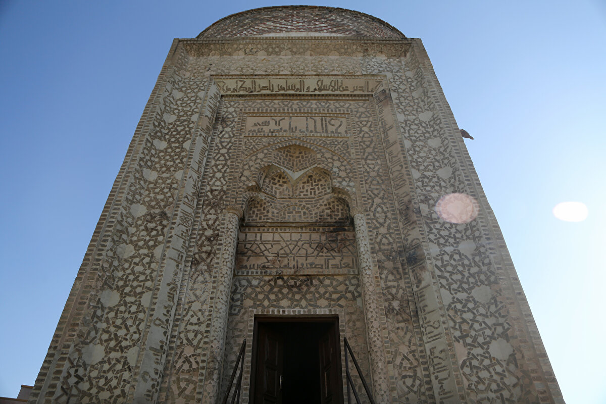 Türbenin girişindeki baş süslemeleri kendi türünde benzersiz olup, taş ve alçı parçaları şeklinde geometrik desenler ve kûfi yazıtlarla bezenmiş. Taç kapı açıklığı mukarnas ile taçlandırılırken silindirik gövdeli yapının dış yüzeyi poligonal şekiller ile dekore edilmiş.