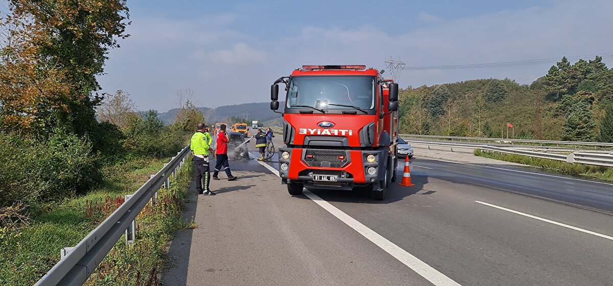 Işık dumanı fark edince otomobilini emniyet şeridine çekip, durumu itfaiyeye bildirdi.