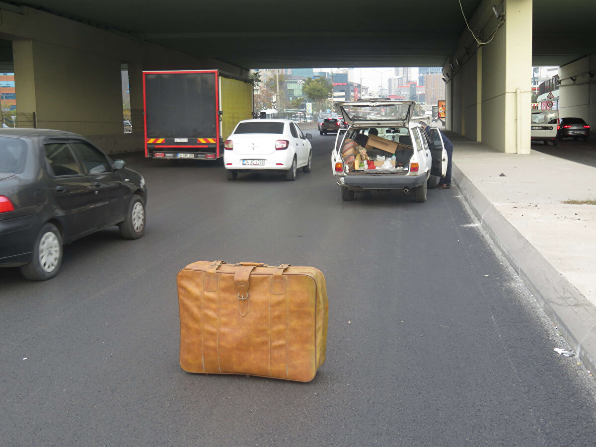Görüntü alınmasına tepki gösteren sürücü, daha sonra bagajdan çıkardığı reflektörü bavulun yanına bıraktı.