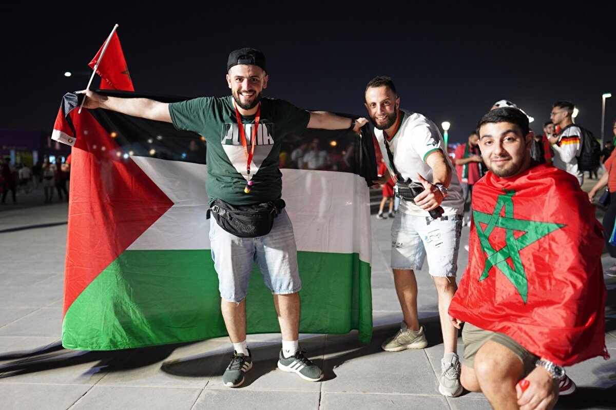 Belçika'yı 2-0 yenen Fas milli takımının taraftarlarının yanında büyük bir Filistin bayrağı açan bir taraftar.