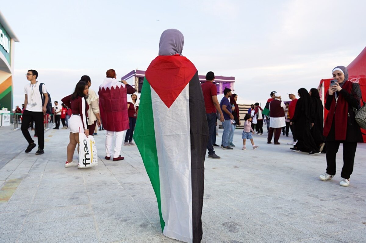 Al Bayt Stadyumu'nda Katar-Hollanda maçı öncesinde Filistin bayrağını sırtına dolayan bir taraftar.