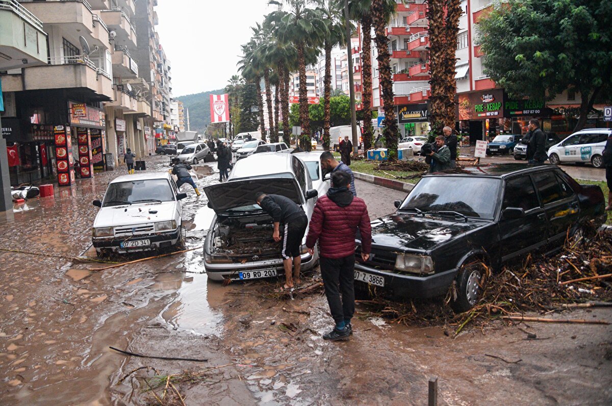 'BELİM BOYUNDA SU VARDI'<br><br>İş yeri sahibi Mehmet Akdinç, "Saat 01.00 sıralarında yağmur başladı. Saat 03.00 civarlarında ise dükkanımıza doğru geldi. Dükkanımız su içinde. Su bayağı yükseldi ve mallarımız su içinde bulunuyor" dedi. Gürcan Gökkaya ise "Belim boyunda su vardı. Motosiklet, araba ne varsa gitti" diye konuştu. Melih Salu da "Araba ileride kahvenin önündeydi, oradan sürüklenerek, 300 metre ileriye geldi. Su akışı, insan boyu kadar vardı" dedi. Ayşe Sıkı da şunları söyledi:
