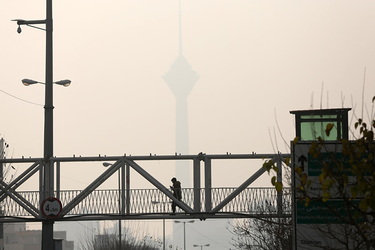 Şehrin sembol yapılarından Milad Kulesi de yoğun hava kirliliği nedeniyle bulanık bir silüete büründü.