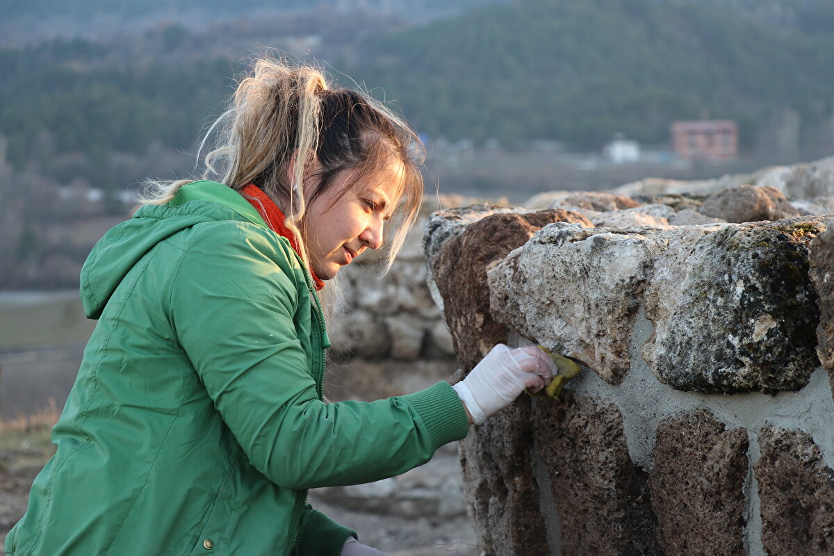 Bulgular bölgenin geçmişine ışık tutarken, antik kenti ziyaret edenler kazı çalışmalarını yerinde görme fırsatı yakalıyor.<br><br>Ziyaretçiler, antik döneme ait paraları, ölülere ait kişisel eşyaları ve 1800 yıllık adak levhası ile Roma askerine ait 1800 yıllık demir maskeyi de yakından inceleyebiliyor.<br>