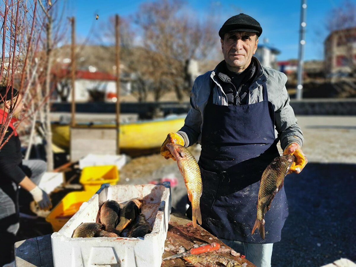 MİSAFİRLER İÇİN BALIK TEMİZLİĞİ<br><br>Bu arada soğuk havaya rağmen güneşli bir gün yaşanan göle gelen vatandaşlar, buz yüzeyinde kilim serip oturarak semaver yaktı. Göl kenarındaki işletmeciler ise yaklaşık 15-20 gün geç başlayan sezon hazırlıklarını hızlandırdı. 