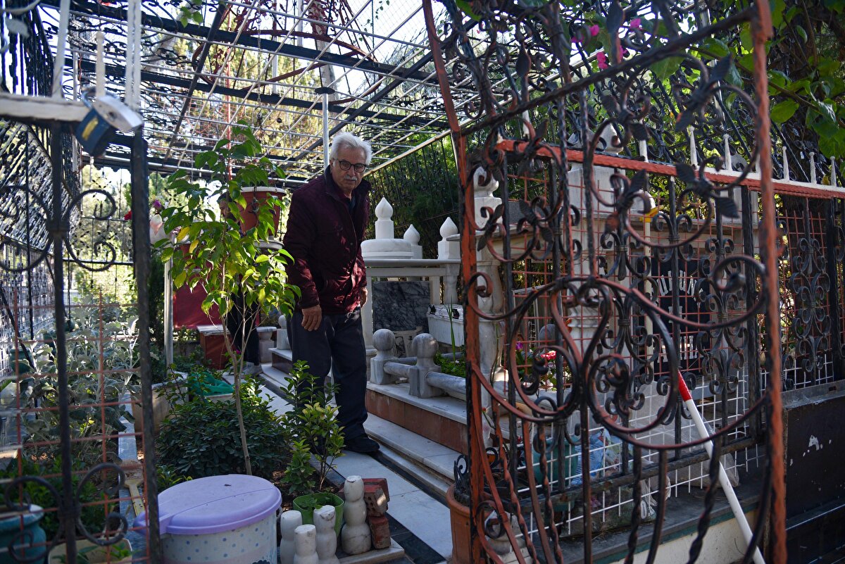 'DİKKAT ELEKTRİK DOKUNMAYIN' YAZISI<br>Karısının kabri ile kendisi için yaptırdığı mezara düzenli olarak bakım yapan Ahmet Düzgün, kullandığı boya, fırça ile hırdavatların çalınmasını engellemek için korkuluğa 'Dikkat elektrik dokunmayın' yazısı astığını dile getirdi. Düzün, uyarıyı hırsızlık amacıyla gelenlere caydırıcı olması için astığını kaydetti.<br>Karısına sevgisinden dolayı söz verdiği gibi mezar yaptırdığını dile getiren Ahmet Düzgün, "Eşimle evliliğim çok mutlu geçti. 32 yıl evli kaldık, aramızda ufak bir sorun bile olmadı. O nedenle karıma vefat ettiğinde en güzel mezarı yapma sözü verdim. Sözümü 23 yıl sonra yerine getirdim. Anıt mezar yaptım. Eşimin mezarının aynısını kendi mezarım için de hazırlattım. Ferforje demir korkuluktan mezarlığı çevirdim. Aydınlatma sistemi ve güvenlik kamerası, internet sistemi yaptırmak istiyorum. Elektrik için aydınlatma direğinden kabloyla elektrik hattı çektim. Belediye elektrik kablosunu kesti" dedi.