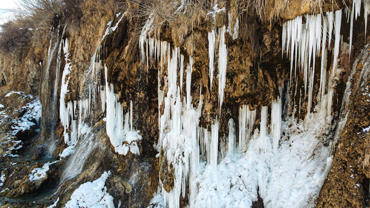Uzun buz sarkıtlarının oluştuğu şelaleye gelen ziyaretçiler fotoğraf çektirdi.<br><br>
