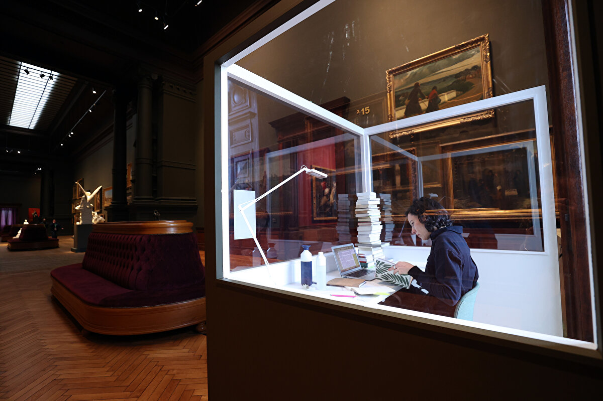 Performansına "Yazar Burada" adını veren De Coster, yemek yeme ve uyuma gibi günlük ihtiyaçlarını ise cam odanın arkasındaki bölümde giderecek.<br>