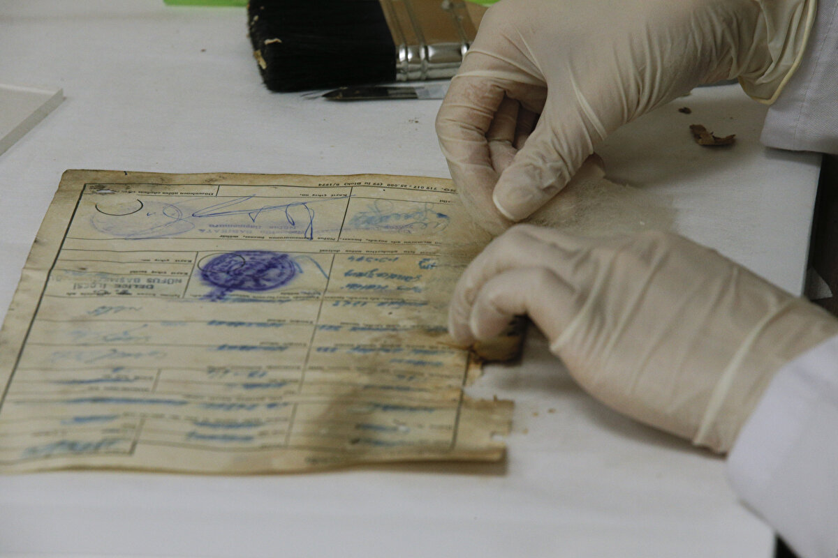 Restoratör Gülsüm Özkan da belgelerin, tasnif bölümünde sınıflandırılmasının ardından kendilerine geldiğini söyleyerek, şunları kaydetti:<br><br>"Restorasyon çalışmalarında, belgelerin ilk olarak genel durumlarına bakıp temizlik çalışmalarına başlıyoruz. Kıvrılmış veya yırtılmış belgeler varsa bunların ilk olarak toparlanması aşamasıyla devam ediyoruz. Temizlik aşamasını kağıt için uygun fırça ve silgilerle gerçekleştirdikten sonra kağıda uygun özel yapıştırıcı ve kimyasallar kullanarak sağlamlaştırma çalışmalarını gerçekleştiriyoruz."