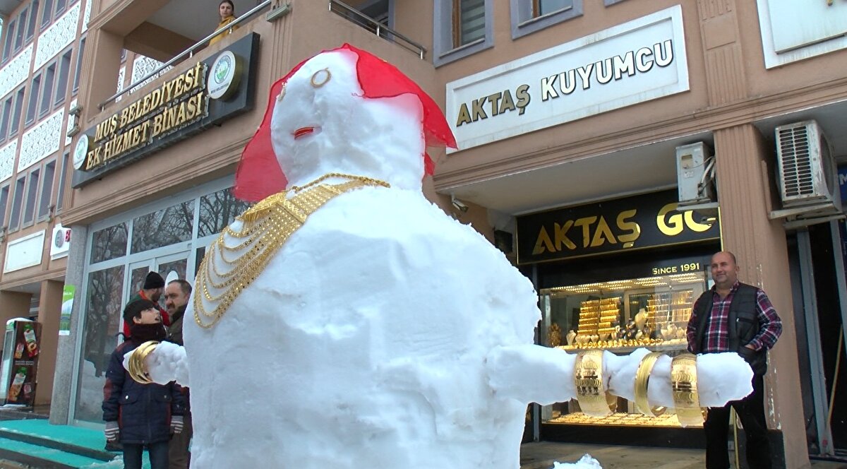 Değeri yaklaşık 400 bin lira olan 350 gram altın takılan 'kardan gelin'i görenler ve esnaf fotoğraf çektirdi. 