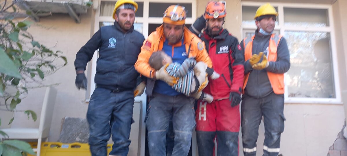 Enkazdan AFAD görevlisinin kucağında çıkarılan Mehmet Tatar, sağlık ekibine teslim edildi.