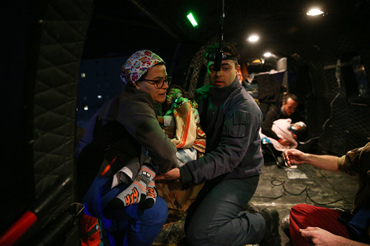 Yüzünden yaralı bebek ile vücudunun çeşitli yerlerinde kırıklar olduğu belirtilen 4 yaşındaki çocuğu, sağlık görevlileri kucaklarında helikoptere taşıdı.