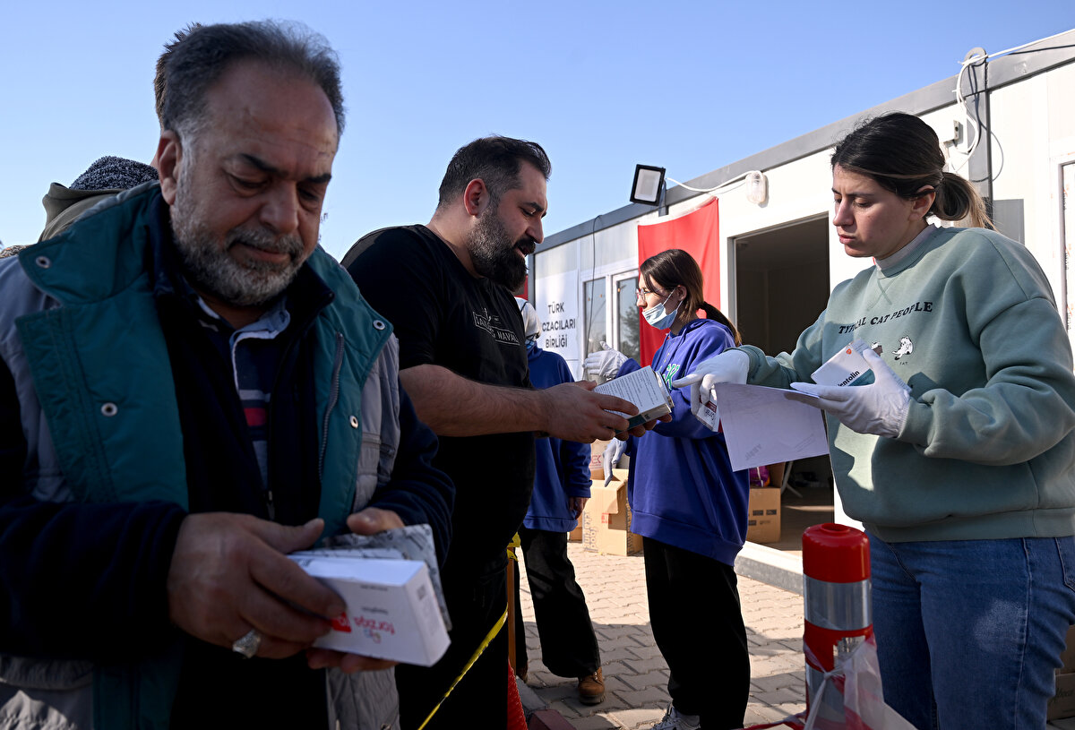  "Burada bir eczanede olabilecek ilaçların yüzde 99'u bulunuyor"<br><br>Ahmet Türen, depremzedeler için ellerinden geleni yapmaya çalıştıklarını belirtti.<br><br>Konteyner eczanenin, İskenderun ve Hatay'ın birçok bölgesine yardıma gelen profesyonel sağlıkçıların ilaç temin ettiği bir merkez haline geldiğini vurgulayan Türen, şunları kaydetti:<br><br>"Bütün ilaçlar burada toplanıyor. Yardıma gelen birçok gönüllümüzün ilaç ve medikal malzeme ihtiyaçlarını da tedarik etmenin gayretindeyiz. Burada bir eczanede olabilecek ilaçların yüzde 99'u bulunuyor. Eczanesi yıkılan, evine giremeyen meslektaşlarımız şu an burada hizmet ediyor. Aynı zamanda depremzedeyiz. Hangi arkadaşlarımızın öldüğünü, hangilerinin yaşadığını bilmiyoruz. Acımızı yaşayamadan seferber olduk. Acımızı inşallah daha sonra milletçe telafi edeceğiz. Şu an hayatta kalanların sağlığını korumakla yükümlüyüz."
