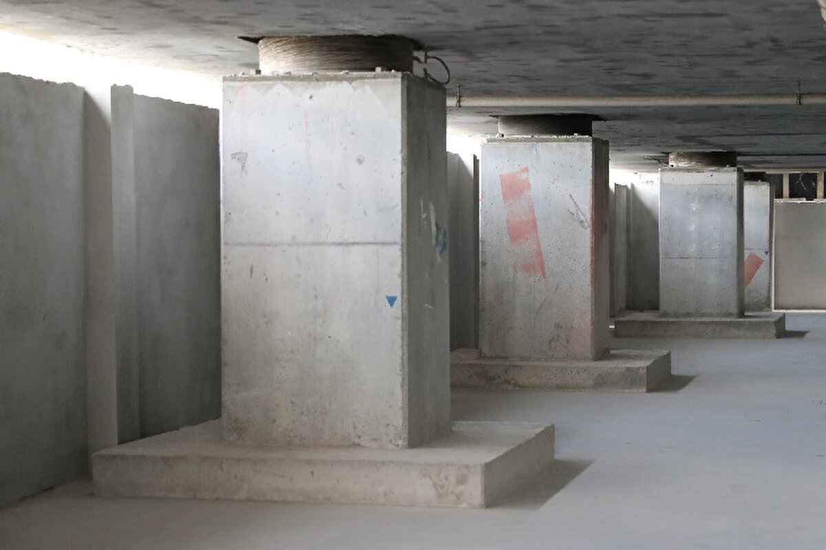 ŞENTÜRK: YANAL İVMENİN ÜST KATLARA ÇIKMASINI ÖNLÜYOR<br><br>Başakşehir'de sismik izolatör kullanılarak yapılan konut projenin Teknik İşlerden Sorumlu Genel Müdür Yardımcısı Ömer Faruk Şentürk konuya ilişkin bilgi verdi. Depremin büyüklüğünden kaynaklı ortaya çıkan yanal ivmenin çok büyük olduğunu söyleyen Şentürk, "Sismik izolatörlerin de amacı bu ivmenin binanın üst katlarına minimum derecede etki etmesini sağlamak. Bizler artık konut projelerinde kullanmaya başladık. En önemli katkısını deprem bölgesindeki şehir hastanelerinde gördük. Ancak bir binada sismik izolatör varsa bu bina sağlamdır yoksa değildir diyemeyiz. Ülkemiz deprem kuşağında bulunuyor, yönetmelikler bunlara göre hazırlanıyor. Konutun yapılacağı zemin çok önemlidir. Zemine uygun yapılan statik proje ardından kalite kontrolden geçmiş doğru inşaat malzemesi, yapının projeye uygun inşa edilmesi ve sahada denetleme gibi faktörleri bir araya getirmek lazım" diye konuştu.