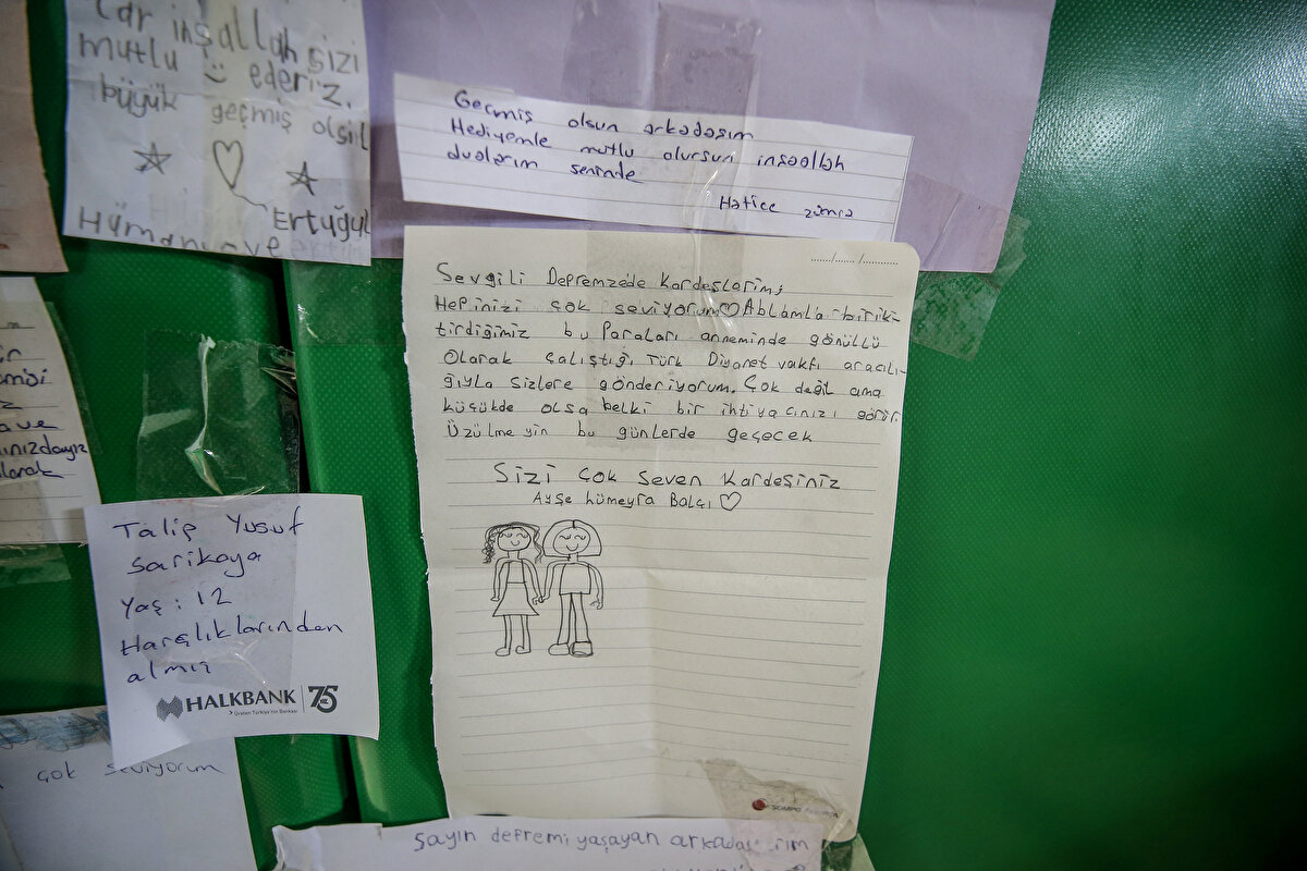 Diyanet İşleri Başkanlığı Hatay Lojistik Merkezi'ne gönderilen insani yardım malzemelerinin tasnif ve ihtiyaca göre sevki, çoğunluğu gönüllülerden oluşan ekip tarafından yapılıyor.<br><br>Yardım malzemelerinin içinden duygu dolu notlar da çıkıyor.