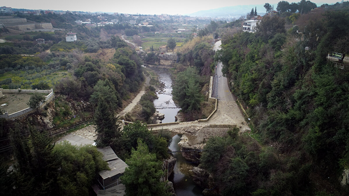 Kahramanmaraş merkezli depremlerin hafif hasar verdiği köprünün bir kısmı, merkez üssü Defne ilçesi olan 6,4 büyüklüğündeki sarsıntıda yamaçtan düşen kayalar nedeniyle yıkıldı.<br>