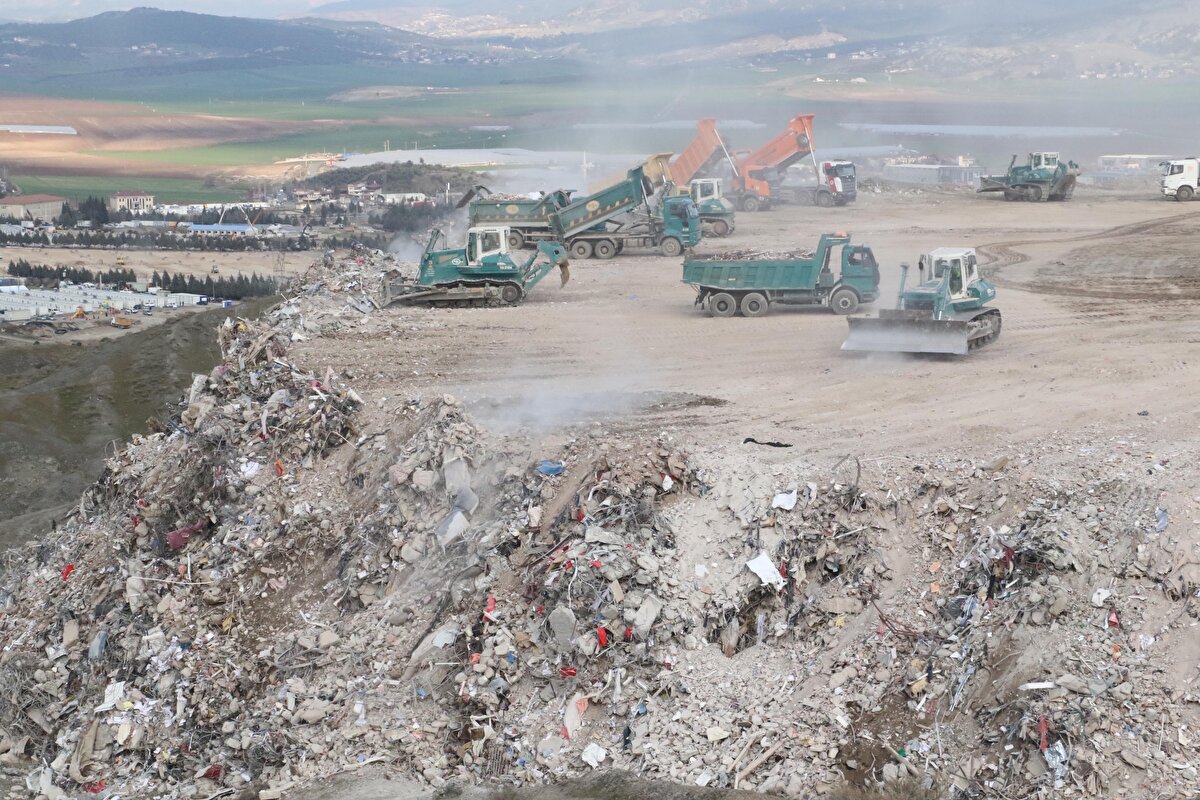 Kamyonların bıraktığı hafriyatlar, iş makinelerince düzenlenip, döküm noktalarındaki tepelere yayılıyor. 