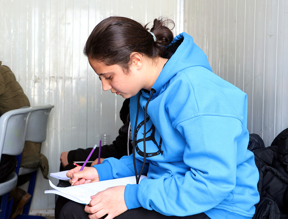 'HER GÜN SARSILIYORUZ AMA AYAKTAYIZ'<br>Samandağ'daki Cumhuriyet İlkokulu'nda görev yapan sınıf öğretmeni Sibel Gümüş, eğitimin devam etmesi gerektiğini, bu nedenle konteyneri sınıfa çevirdiklerini anlattı. Öğrenciler için ellerinden geleni yapacaklarını belirten Gümüş, "Çocukların gözlerinde korku ama bunun yanında çok büyük bir umut da var. Gözlerine baktığınızda, her şeyi unutuyorsunuz. Umarım hepsi, hedeflerine ulaşır; istedikleri liseye yerleşirler. Sonuna kadar destek olmaya devem edeceğiz. Burası, bizim memleketimiz. İlçeyi terk edebilirlerdi ama gitmediler. Onlar gitmedilerse ve Mustafa Kemal Atatürk önderliğinde bu ülkeyi bu noktaya getirebildiysek zorlu günleri de aşarız. Umarım herkes dimdik durur. Her gün sarsılıyoruz ama ayaktayız" dedi.