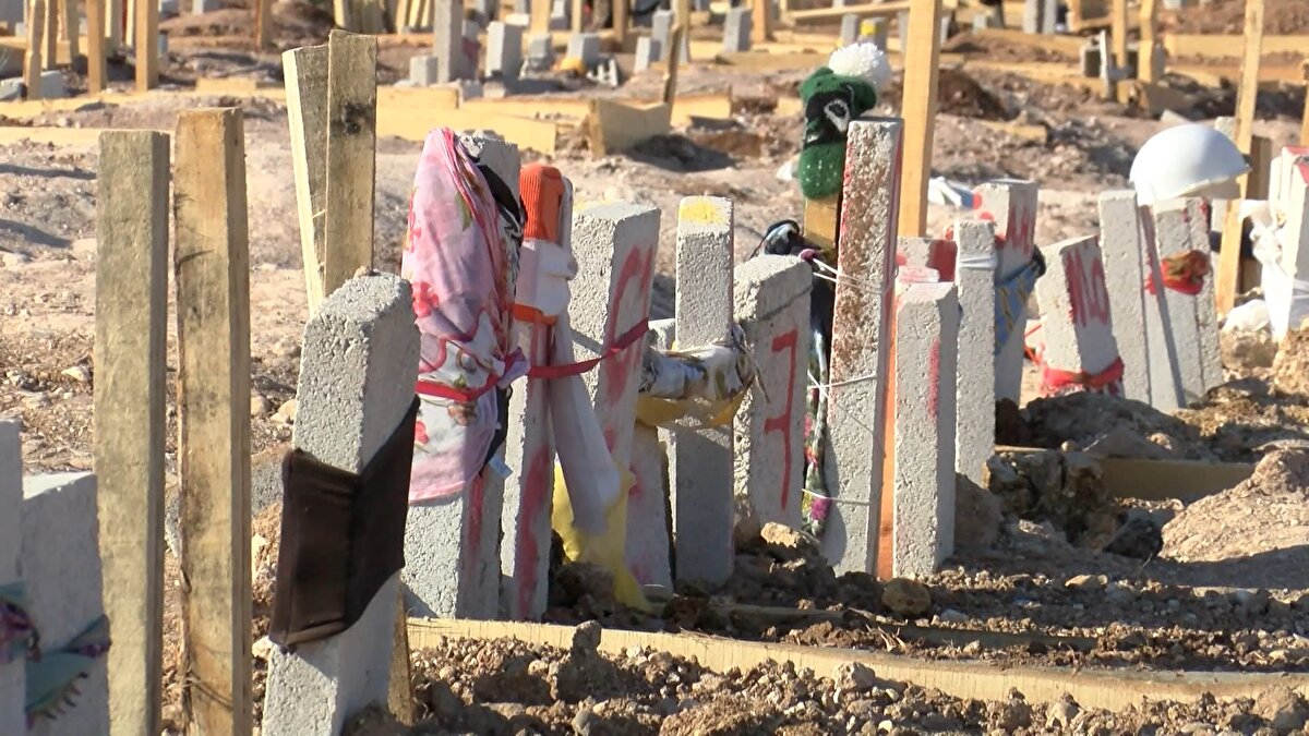 Hayatını kaybedenlerin yakınları mezar yeri belli olması için mezar başına çeşitli eşyalar astı.