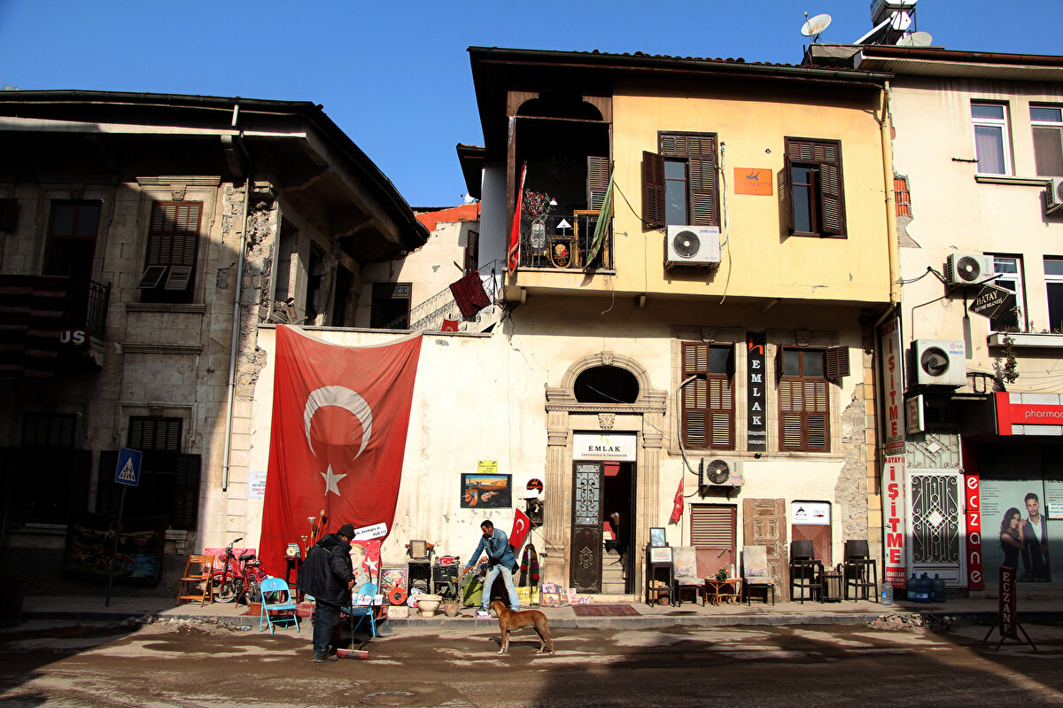 'ARTIK GÜNLERİ SAYMIYORUZ'<br>Caddedeki sessizliğini, hafriyat kamyonlarının ardından ilk kez bir antikacının kaldırımındaki kasetçalar bozdu. Depremin izlerini silmek için arkadaşlarıyla iş yerinin önünü süpüren antikacı ve gayrimenkul danışmanı Mehmet Sercan Sincan, nostaljik şarkılarla çevredekilere moral vermeye başladı. Çok sayıda yakınını ve dostunu kaybettiğini belirten Sincan, hayatın devam etmek zorunda olduğunu belirtti. Sincan, "Artık günleri saymıyoruz ancak yas 3 gündür. Gördüğünüz gibi biz tekrar bir enerji ve hayat akışının başlamasını istiyoruz" dedi.