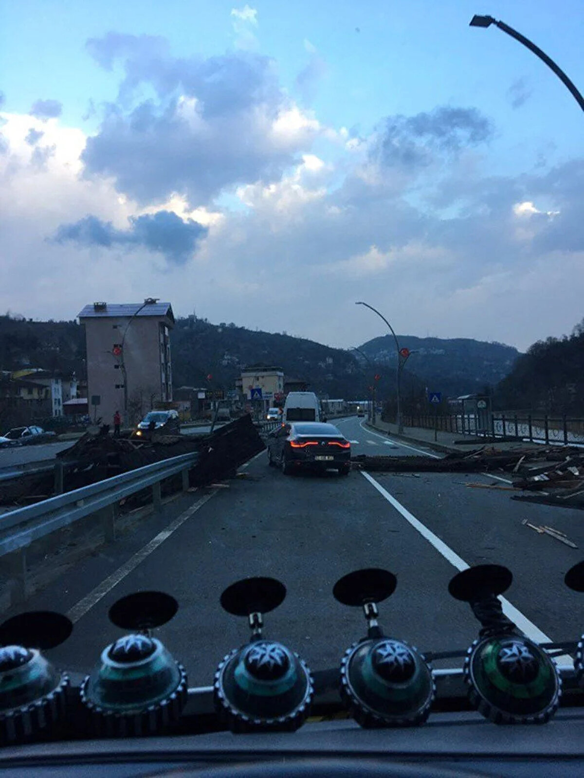 Binalardan uçuşan yapı malzemeleri ise çevreye saçıldı. Park halindeki araçların üzerine düşen çatı parçalarının yanı sıra sürüklenen dallar, Güneysu-Rize Otoyolu'nu kısmen trafiğe kapattı.<br><br>