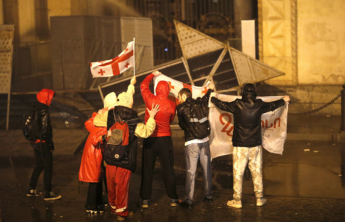 Parlamentonun girişinde kurulan demir bariyeri kaldıran göstericiler birkaç polis arabasına da hasar verdi.