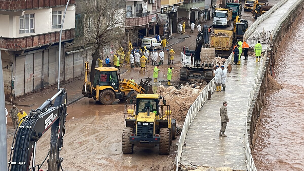 DSİ ekipleri, selin getirdiği dere yatağındaki balçık ve atık yığınını temizliyor.<br><br>Tut ilçesinde 15 Mart'ta şiddetli sağanak sonrası yaşanan selde konteynerin sürüklenmesi sonucu Selma Sarıkaya ve kızı Emine Sarıkaya'nın cesetlerine ulaşılmış, kaybolan Fatma ile 1,5 yaşındaki kızı Zeynep Zümra Tekdal'ın bulunması için çalışma başlatılmıştı.<br><br><br>Deprem bölgesinde etkili olan şiddetli yağış su baskınlarına yol açmıştı. Adıyaman'da bahçedeki konteynerin suya kapılması sonucu 2 kişi hayatını kaybetmişti. Şanlıurfa'da ise 16 kişi yaşamını yitirmişti.