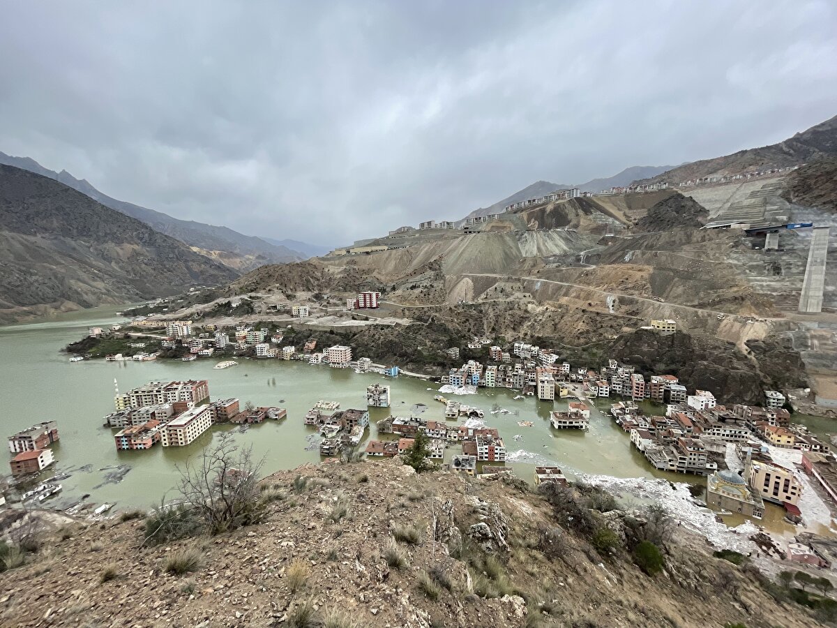 Büyük kısmı su altında kalan eski ilçe merkezinde, güvenlik gerekçesiyle araç ve yaya girişine izin verilmiyor. Yol, beton bariyer konularak ve toprak dökülerek ulaşıma kapatıldı.<br>