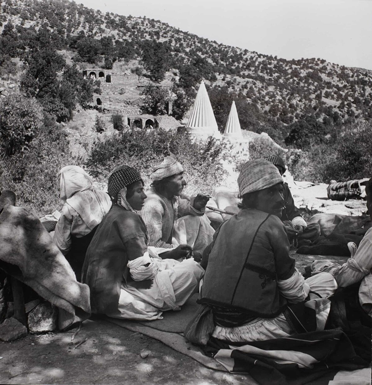 Laliş'teki yıllık festivale katılan Yezîdîler, Ekim 1946.<br><br>Bu fotoğraf, Şeyh Adî ve Şeyh Hasan'ın türbelerinin konik kulelerine bakan bir yamaçta oturan kadınlı erkekli bir grup Yezîdîyi göstermektedir. Kersting, bu etkinlikte geçirdiği süreden sonra bir daha Irak’a dönmemiştir.