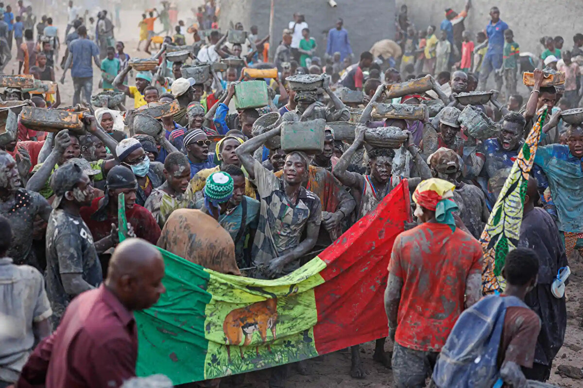 Erkek, kadın ve çocuklar kolektif olarak, 20 metre yüksekliğindeki camiyi şiddetli yağmurların ve sıcak havanın neden olduğu çatlak ve çatlakların neden olduğu erozyondan koruyan toprak, su, pirinç kepeği, karite yağı ve baobab tozu karışımı olan “banco” ile sıvıyorlar. 