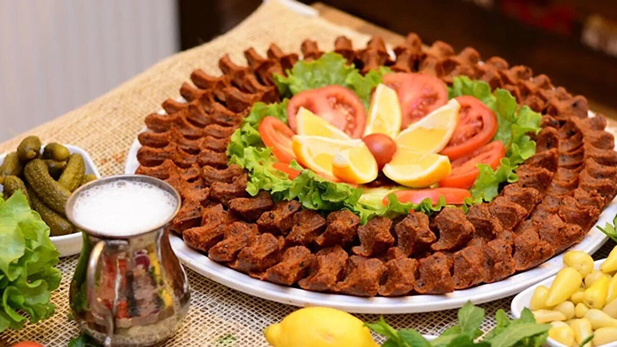 "ETTEN DAHA FAZLASI VAR" <br><br>Kamar, “Çiğ köftemizde et yok ama etten daha fazlası var. İçerisinde 12 bitki ve baharat, ayrıca ceviz, fındık, fıstık var. Emin olun, etli çiğ köftede aldığı lezzetin çok daha ötesini hem de daha sağlıklı bir şekilde bütün vatandaşlarımız alıyor. Etli çiğ köftenin temel maddesi et. Eti bulgurla yoğurarak içerisine de salçasını, bitki ve baharatını koyarak oluşturduğunuz bir yiyecek türü. Etsiz çiğ köftede, etin dışında etten daha fazlası var. Etteki kalorinin de daha fazlası var. B12 vitaminin daha fazlası var, Omega 3 içeriyor, özellikle eti aratmayan ceviz, fındık, fıstık içerdiği için. Sağlık açısından da, lezzet açısından da, şifa açısından da etsiz çiğ köfte her yönüyle etli çiğ köfteden daha iyi" diye konuştu.