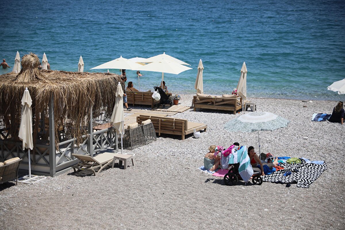 Şezlong, şemsiye kiralama yöntemiyle farklı seçenekler sunan işletmeleri tercih edenler, yüzme ve güneşlenmenin yanı sıra canlı müzik performansı ya da müzik dinletisiyle tatilin keyfini çıkarıyor.<br><br>Ekstra ödemeyle müşterilerine yiyecek, içecek hizmeti veren işletmelerde, şezlong, şemsiye 150 liradan başlayan fiyata kiralanıyor.