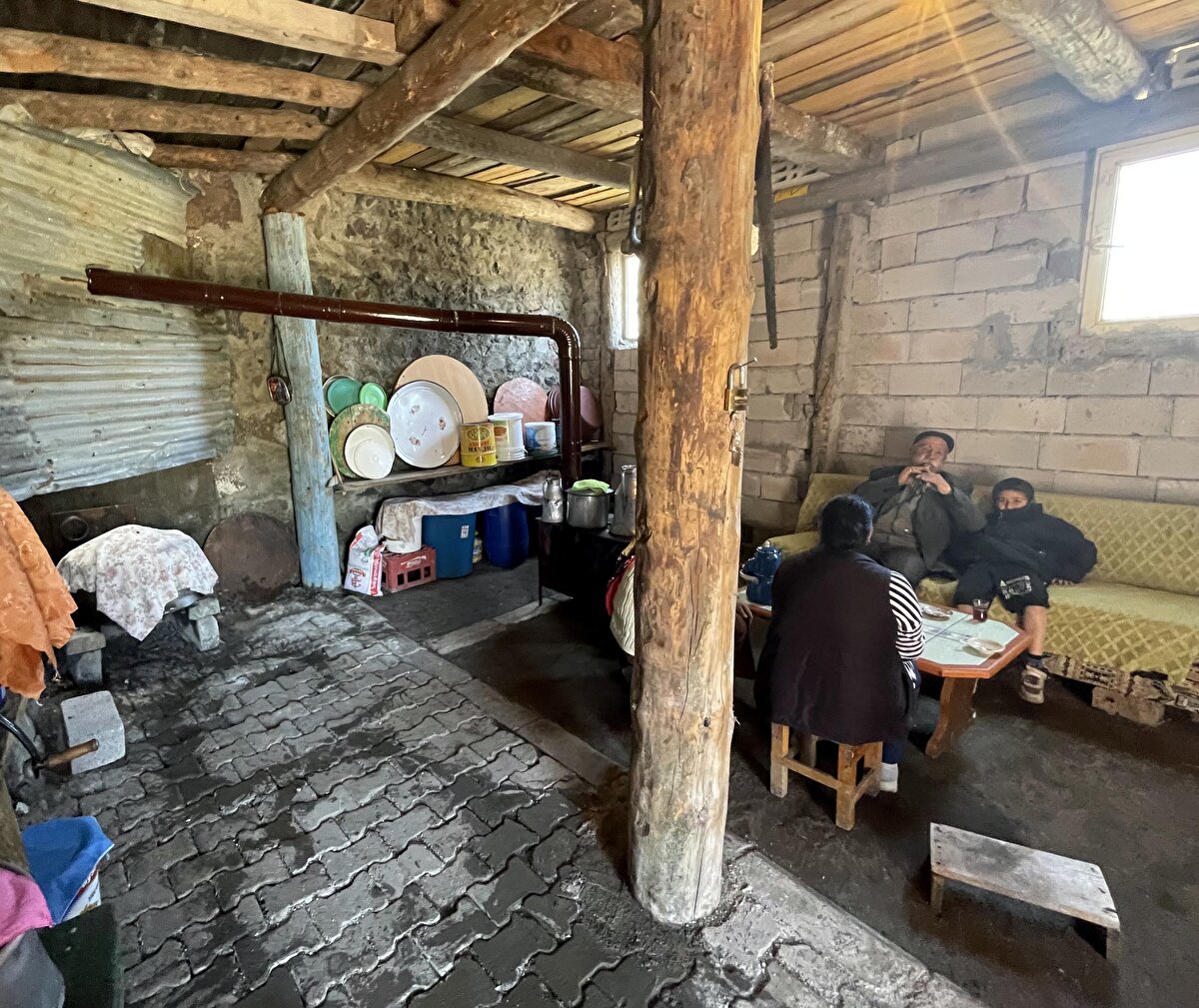 "Bizim bu halimizi görenler şaşırıyor"<br><br>Ardahan'ın yüksek kesimlerinde bulunan ve her sene karın ilk düştüğü yerlerden biri olan merkeze bağlı Yaylacık köyünde yaşayan 83 yaşındaki Mustafa Demirbaş, AA muhabirine, kıştan çıkmalarına rağmen hala soba yaktıklarını söyledi.<br><br>Sobasız yaşamın bölgede şimdilik mümkün olmadığını dile getiren Demirbaş, "Birçok bölge sıcaktan kavruluyor bizler de duyuyoruz ancak biz hala soba yakıyoruz. Bizim bu halimizi görenler şaşırıyor ama gerçekler bunlar. Tabii ki bu durum bizi masrafa sokuyor. Yapacak bir şey yok. Şartlarımız bu. Her tarafta yaz sıcakları hakimken biz hala sobanın başındayız." dedi.<br><br>Sobanın keyfini çıkarmak için demlenen çayı yudumlayıp ney çalan Demirbaş, ev halkına da neşeli ortam yaşatıyor.<br><br>Demirbaş'ın kızı Songül Demirbaş ise soba yakmalarını başka şehirlerdekilere anlatamadıklarını belirterek, "İnsanlara 'Biz hala soba yakıyoruz' dediğimizde bize inanmıyorlar çünkü onlar sıcaktan kavrulurken bizim burada soba yakmamız çok inandırıcı gelmiyor. Bizim bu halimizi görenler şaşırıyor." ifadelerini kullandı.