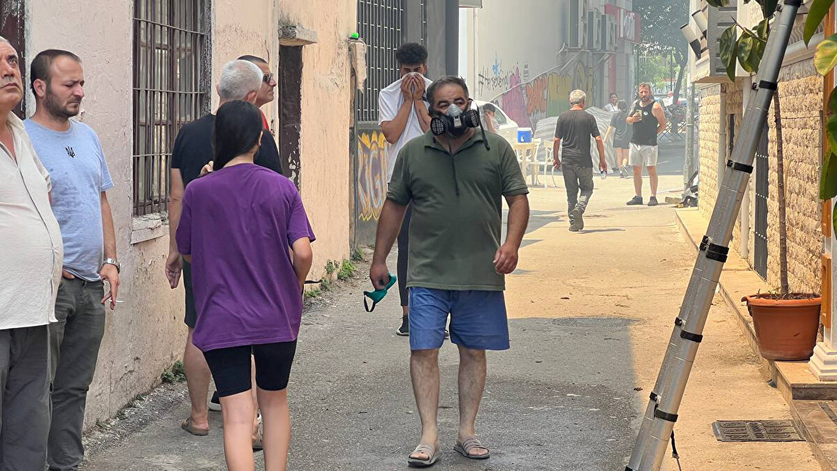 MASKE VE TİŞÖRTLE YÜZLERİNİ KAPATTILAR<br><br>Bazı vatandaşlar maske takarak veya tişörtleriyle ağızlarını kapatarak söndürme çalışmalarına yardım etti.