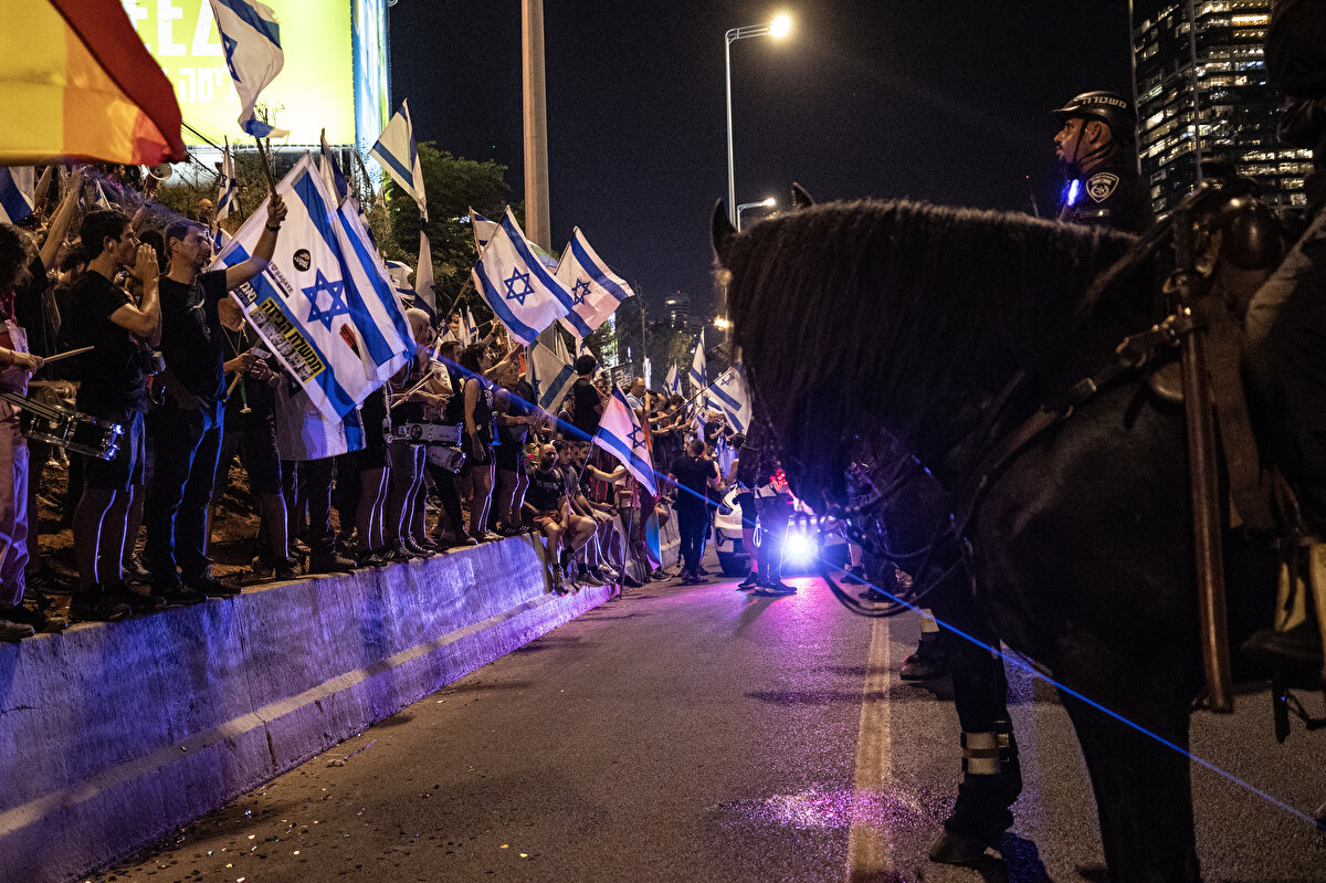 Netanyahu'nun konuşmasını tamamlamasıyla birlikte hükümet karşıtı protestoların merkezi haline gelen Tel Aviv'de gösteriler başladı.<br><br>Yüzlerce kişilik gösterici grubu, Tel Aviv'deki hükümet kompleksinin bulunduğu Kaplan Caddesi'nde toplandı. Bir grup, Tel Aviv'in ana arteri Ayalon otoyolunu trafiğe kapattı, yolda uzun araç kuyrukları oluştu.