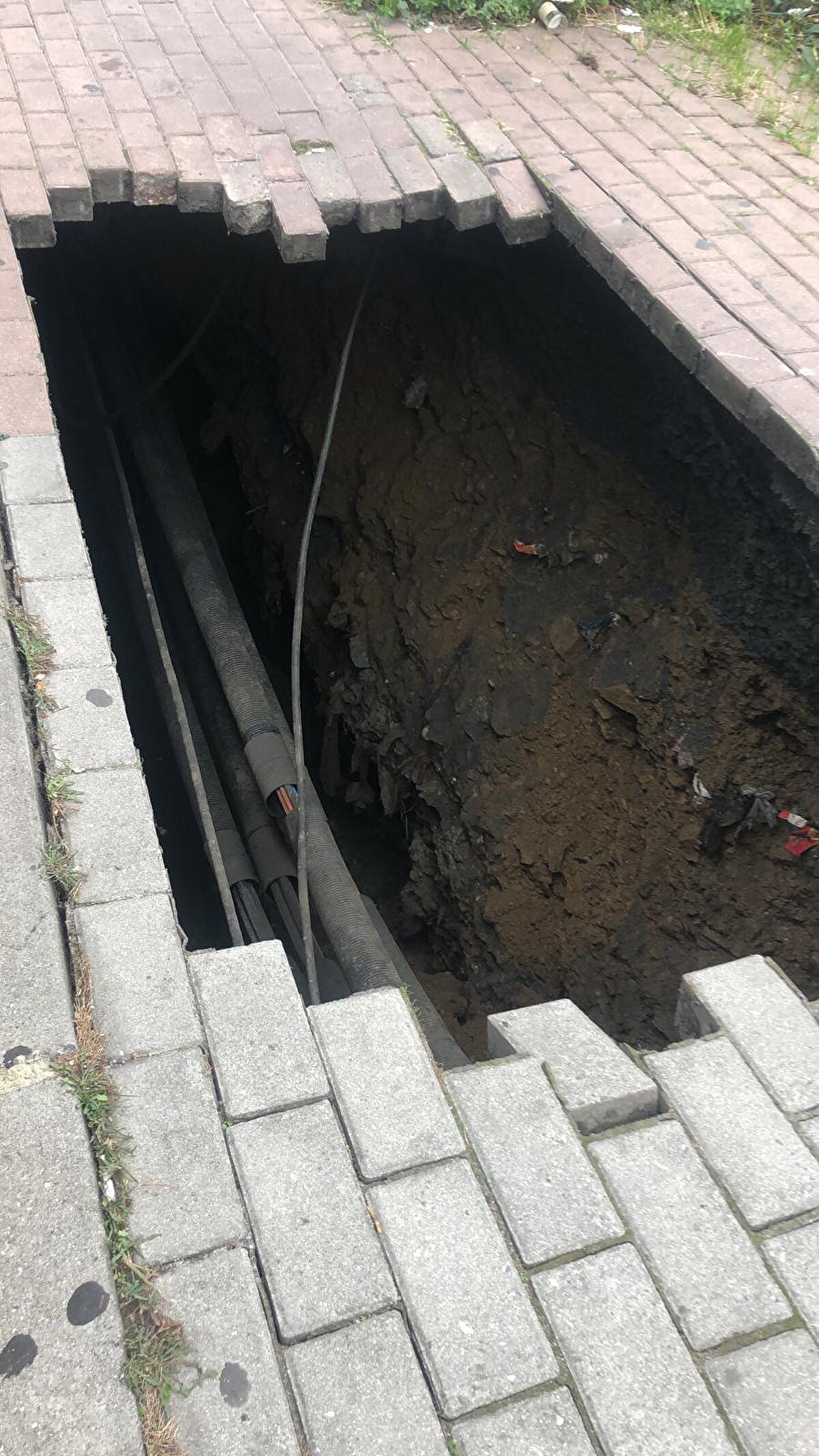 Kaldırımdaki çökmenin devam etmesi nedeniyle güvenlik tedbiri alan ekipler, sokağı giriş ve çıkışlara kapattı.