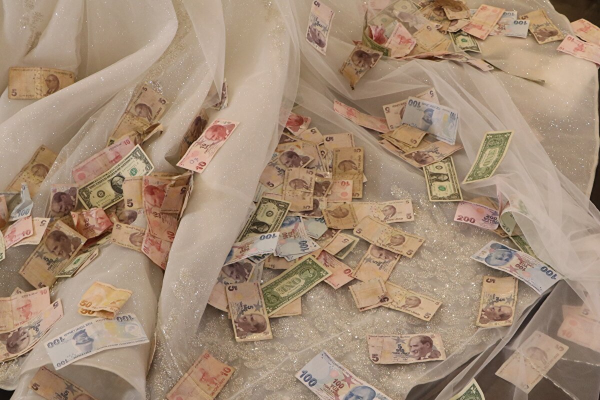 Altınların ağırlığı nedeniyle hareket edemeyen geline yakınları yardımcı olurken, altın takmayan davetliler ise salondaki sandığa para koyarak isimlerini yazdıkları zarfları attı. 