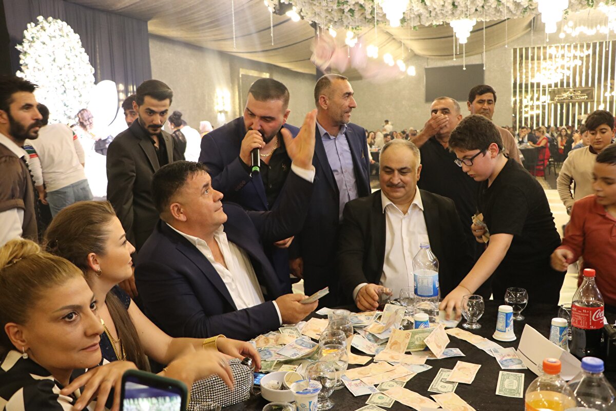 Düğünde dans eden çiftin ve halay çekenlerin üzerine davetliler, 1 dolarlık banknotlar ile TL saçtı.<br>