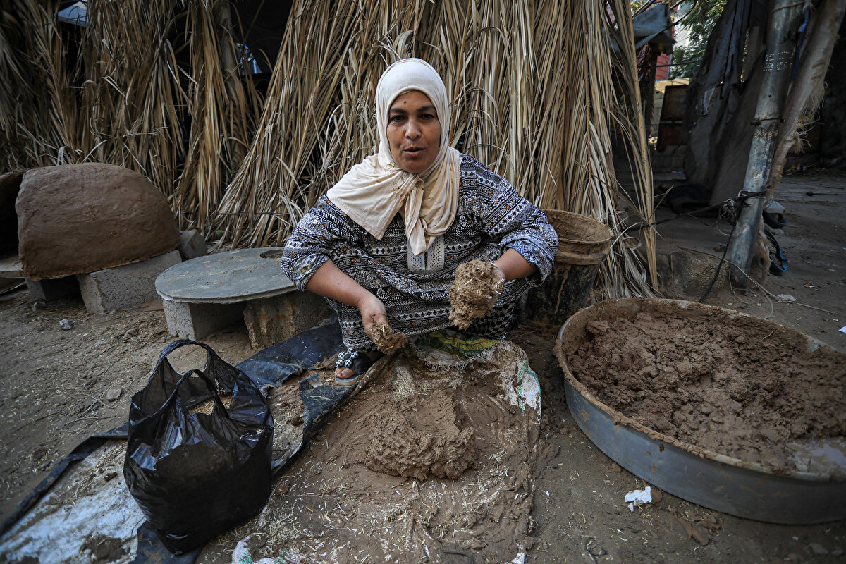Geleneksel kil fırınları (Tabun) yapan İnşirah Salem el-Akra, İsrail ablukası altındaki Gazze Şeridi'nde yakıt ve elektrik sıkıntısı yaşanırken Filistinlilerin alternatif yemek pişirme yolları aramasıyla işlerinde artış yaşıyor.