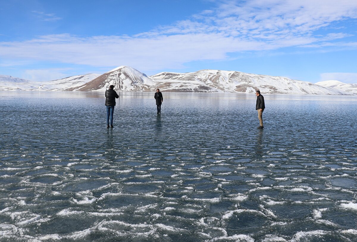 Çevresi karla kaplı göle gelen bazı vatandaşlar, buz üzerinde yürüyüş yapıp fotoğraf çektirdi.