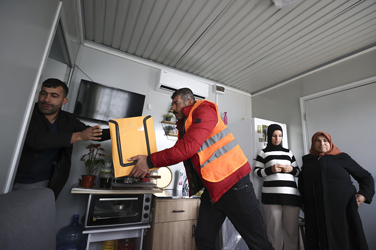 Ardından komşularıyla vedalaşan aile bireyleri, kalıcı konutlardaki GK-5 blok daire 3'e gelerek ekiplerin desteğiyle eşyalarını evlerine yerleştirdi.