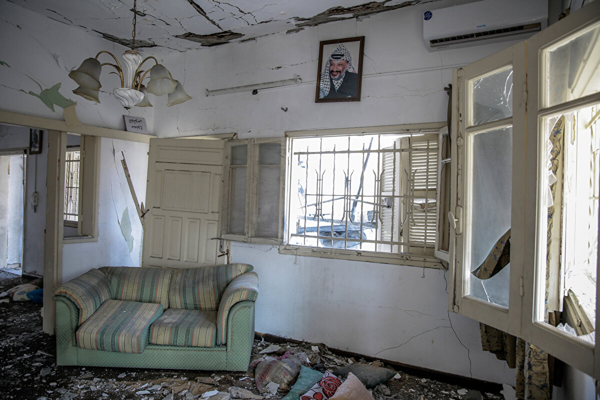 İsrail bombardımanı sonucunda evin salonundaki mobilyalar parçalandı, oda tamamıyla toz ve külle kaplandı.