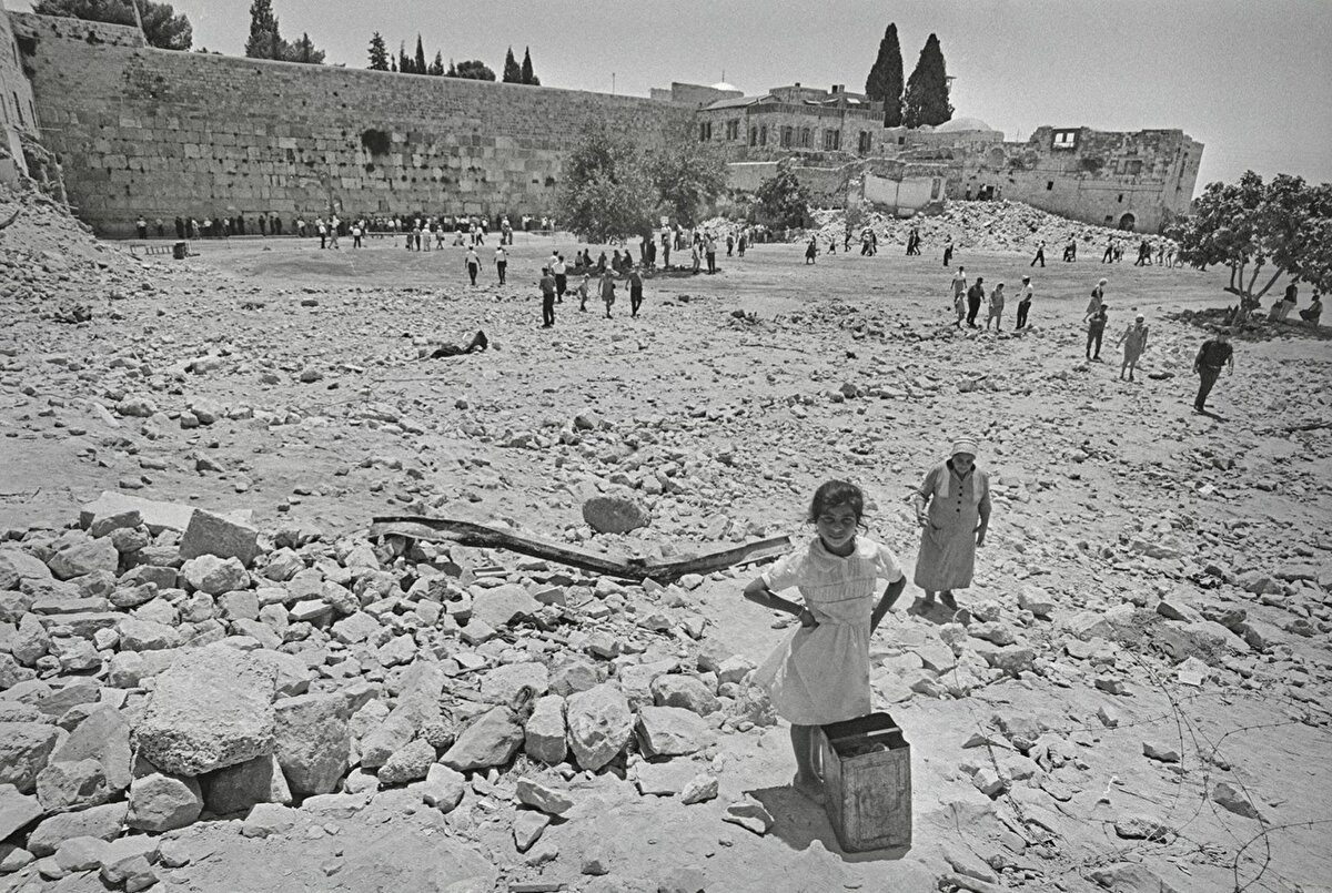 Ağlama Duvarı’nın önünde bugün görülen meydanın açılması için tarihî mekânlar yerle bir edilirken, evlerinin moloz yığınına dönüşmesini izleyen burada yaşayan 6 bin dolayındaki Arap nüfus da sur dışına sürgün edildi. 
