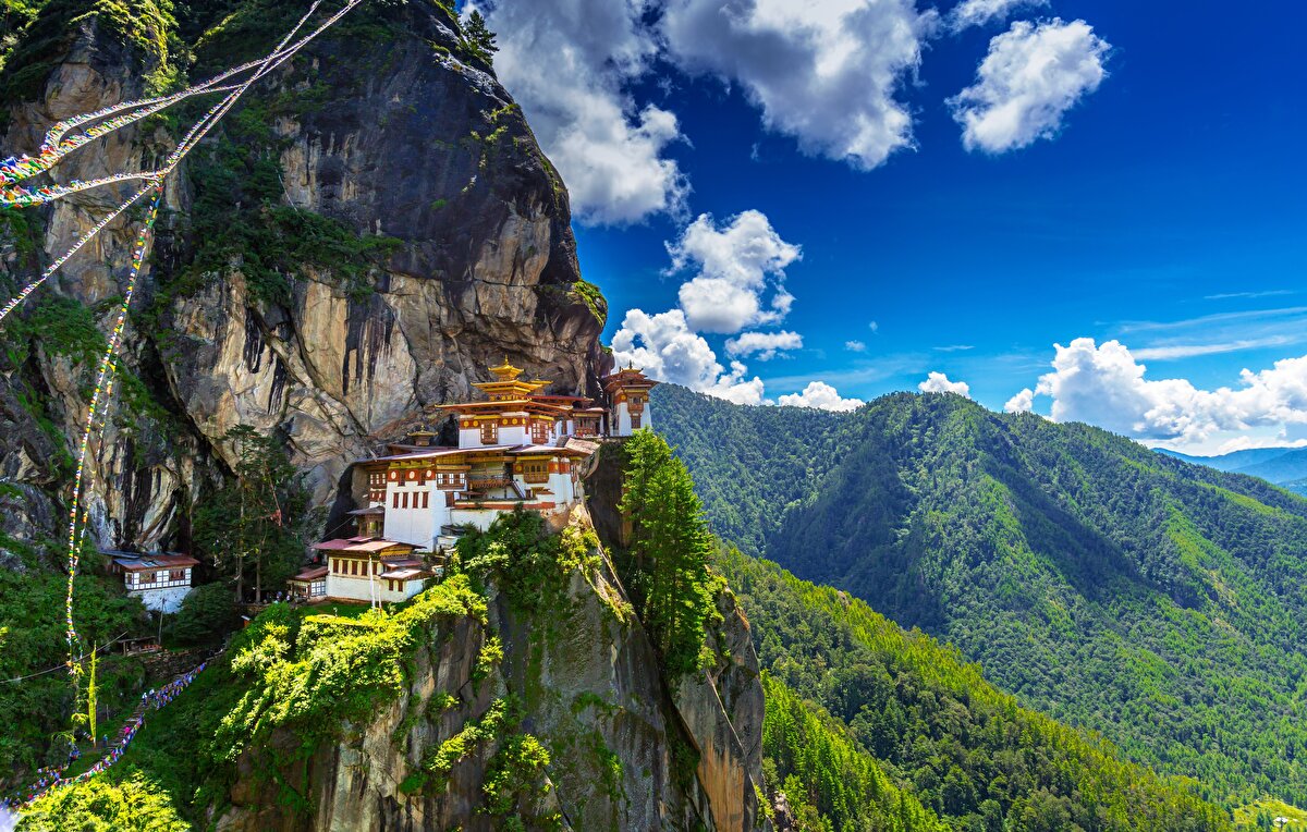 6. Kaplan Yuvası Manastırı- Butan<br> Bhutan'da Paro Vadisi'nde bulunan bir Budist manastırıdır. 1692 yılında Taktsang Senge Samdup mağarasının etrafında inşa edilmiştir. Manastır, günümüzde Bhutan'ın kültürel bir simgesi olarak kabul edilmektedir. Üç bin metre yüksekliğindeki dağ yamacına kurulmuş tapınağın hikayesi de oldukça efsanevidir. Rivayete göre milattan sonra sekizinci yüzyılda, Guru Rinpoche (Padmasambhava olarak da bilinir) adındaki bir rahip, Bhutan'da Budizmi yaymak istemiş ve Kaplan Yuvası olarak bilinen bu dağ yamacındaki mağaraya, dişi bir kaplan şekline giren Prenses Yeshe Tsogyal'ın sırtında uçarak gelmiş. Guru Rinpoche'un mağaraya gelme amacı ise Simgey Sandrup adındaki bir şeytanla savaşmakmış.Guru Rinpoche, Kaplan Yuvası mağarasında; üç yıl, üç ay, üç hafta, üç gün ve üç saat meditasyon yapmış. Yine rivayete göre Guru Rinpoche, Kaplan Yuvası Tapınağı'nda yer alan sekiz farklı tapınakta, sekiz farklı forma girebiliyormuş. Guru Rinpoche, Bhutan'a gelmeden önce bölgede çok çeşitli inançlar bulunuyormuş. Fakat Guru azmetmiş ve Bhutan halkını Budizm'e döndürmüş. Bu noktadan sonra Bhutan halkı Guru Rinpoche'u bir yol gösterici, mentor olarak benimseyip ona çok büyük saygı duymaya başlamışlar.