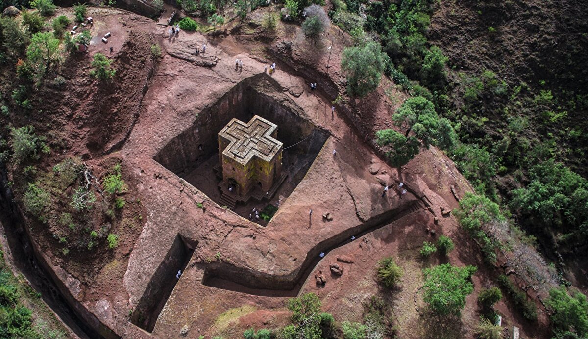 8. St. George Kilisesi- Etiyopya<br>Etiyopya Kralı Gebre Meskel Lalibela’nın Kudüs’e giden yolların güvenli olmadığı gerekçesiyle ikinci bir Kudüs’ü burada inşa ettirmek istemesinden ötürü bölge, “Etiyopya’nın Kudüs’ü” olarak adlandırılıyor.<br><br>Düşmanların fark etmemesi için yer altına inşa edilen yapıların her biri, taşıdığı sembollerle dönemin ve bugünün Etiyopya’sında yaşanan güçlü dini hayatı anlamaya yardımcı oluyor.<br><br>Amhara eyaletinde kralın adını taşıyan Lalibela kasabasında yer alan 11 kaya kilise her gün Etiyopyalıların düzenli olarak ibadet ettiği ve hac için geldiği bir mekan olmakla birlikte yılın her döneminde de turistlerin akınına uğruyor.<br><br>Lalibela, Hristiyanlıkla 4. yüzyılın başlarında tanışan ve bu dini ilk resmi din olarak kabul eden devletlerden biri olan Etiyopya'daki Hristiyan kültürün en önemli yansımalarından biri konumunda.