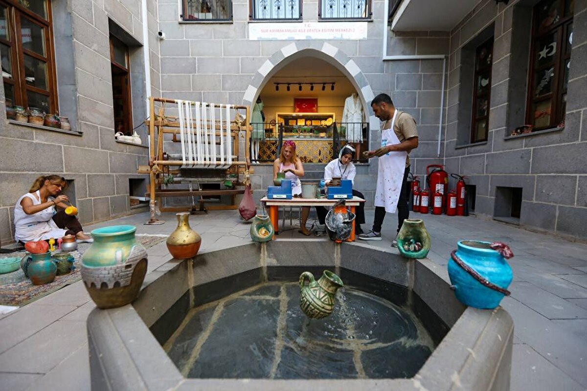 Sur Kaymakamlığı Aile Destek Merkezinde (ADEM) düzenlenen kursa katılan 13 kadın, seramik ve çömlek atölyesinde usta öğreticiler eşliğinde çamur ve killi topraktan küp ve testiler hazırlıyor.