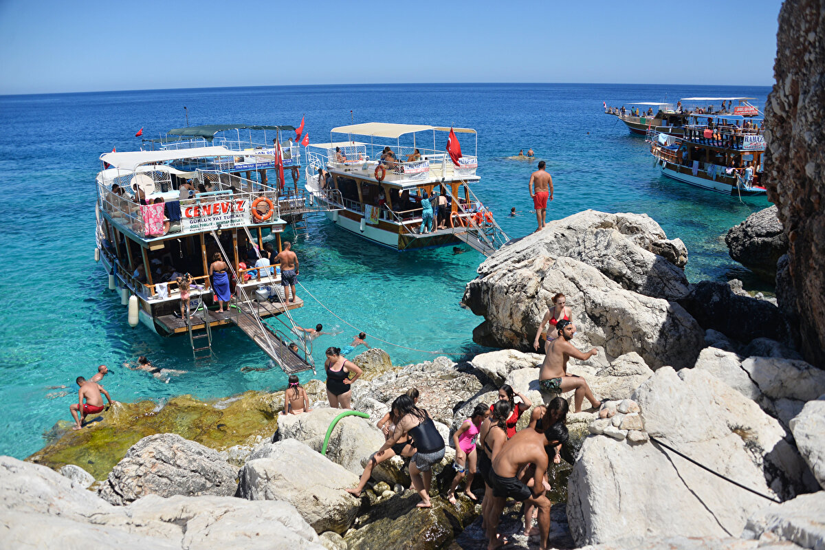 'ADRASAN KOYUNUN HER YERİ TEKNE OLDU'<br><br>Bölgede daha önceleri inceleme yapan ve rapor hazırlayan Akdeniz Üniversitesi Su Ürünleri Fakültesi’nden Prof. Dr. Mehmet Gökoğlu, bölgenin kaderine terk edildiğini ve tekne işgaline uğradığını söyledi. İşin kontrolsüz şekilde büyüdüğünü belirten Prof. Dr. Gökoğlu, “Adrasan koyunun her yeri tekne oldu. Türkiye’nin en güzel koylarından biriydi. Koyun 3’te 2’sini tekneler kaplıyor. Teknelerin çok olması sintine, petrol, yağ ve atık anlamında kirliliğe neden oluyor. Adrasan koyu koyluktan çıktı" dedi.<br><br>Günde 6 bin ziyaretçinin çok ciddi bir sayı olduğunu belirten Prof. Dr. Mehmet Gökoğlu, “Adanın etrafını 6 bin kişi sarsa yüzecek yer kalmaz. Üzülüyorum. Hiçbir şey planlı yapılmıyor. Ne koparabilirsek ülkenin bir yerinden, onun peşinde herkes" diye konuştu.