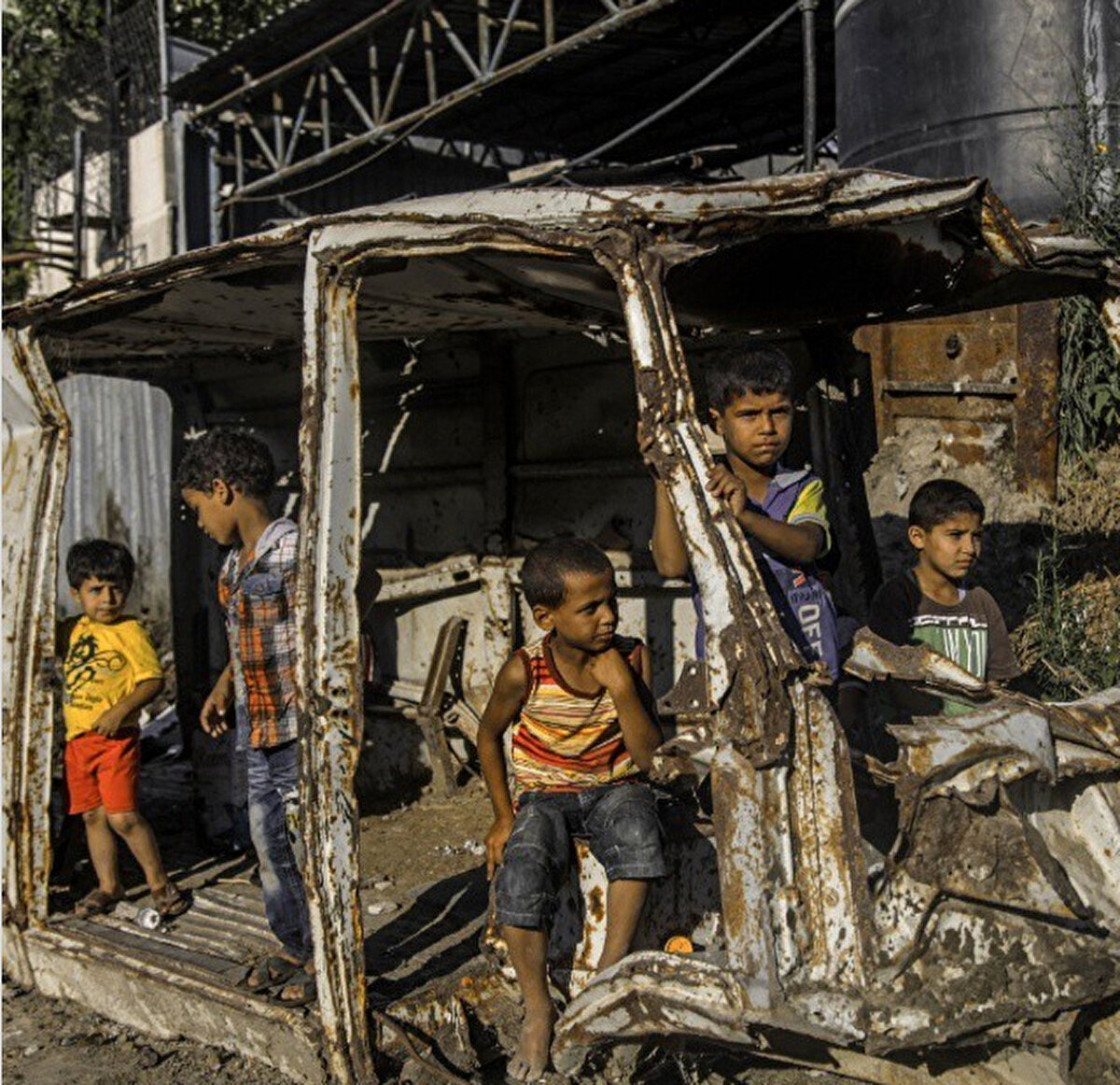 Gazze'de bir arabanın kalıntılarıyla oynayan Filistinli çocuklar, 5 Ağustos 2015. 