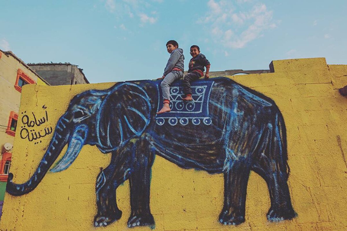 Filistinli çocuklar evlerinin önünde, Şati Mülteci Kampı’nda yaşayan sanatçıların çizdiği duvarda oynuyorlar, 17 Aralık 2015. 